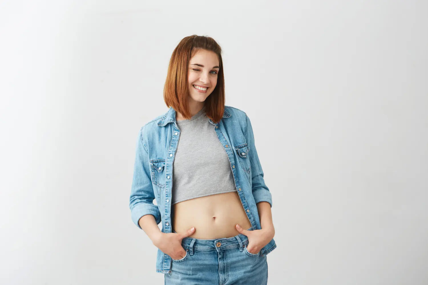 Uma jovem mulher está em forma sem gordura localizada na barriga